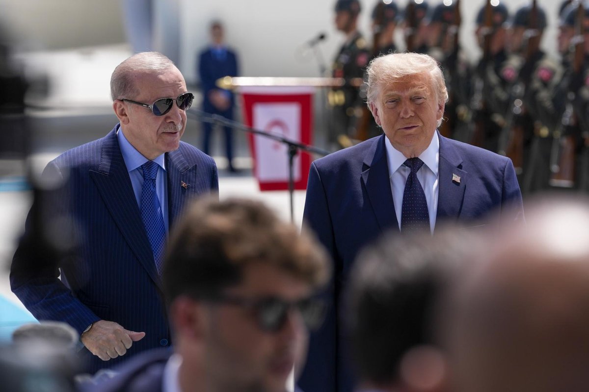 President Erdoğan stands beside US President Trump at an official welcome ceremony in Ankara, a military honor guard lined up behind them.