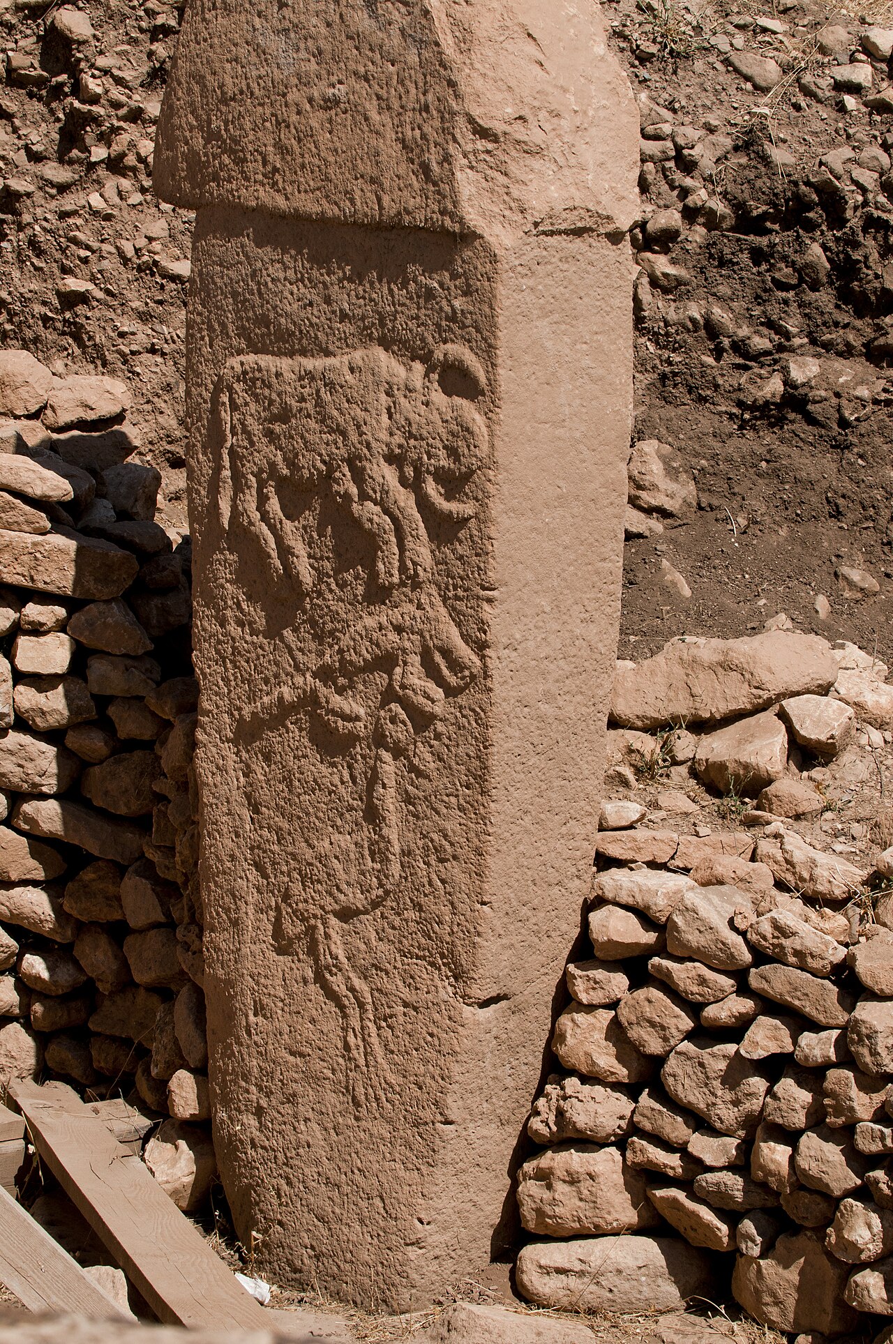 A T-shaped limestone pillar at Göbeklitepe carved with reliefs of a bull, a fox and a crane