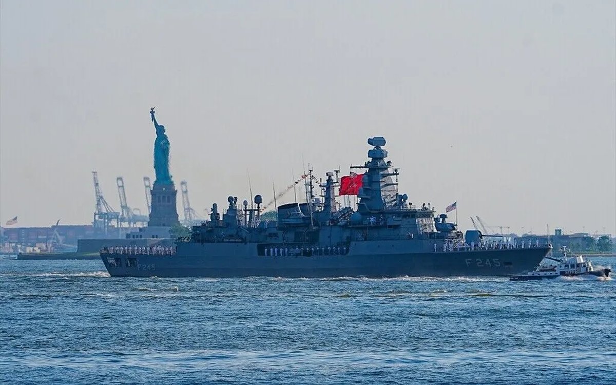 The Turkish frigate TCG Oruçreis passes the Statue of Liberty in New York Harbor, its crew manning the rails