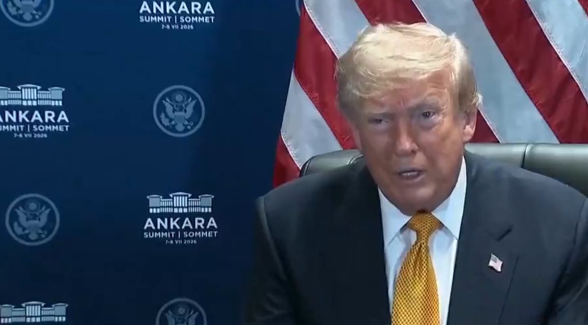 US President Donald Trump speaking at the NATO Ankara Summit, seated before a US flag and the summit backdrop